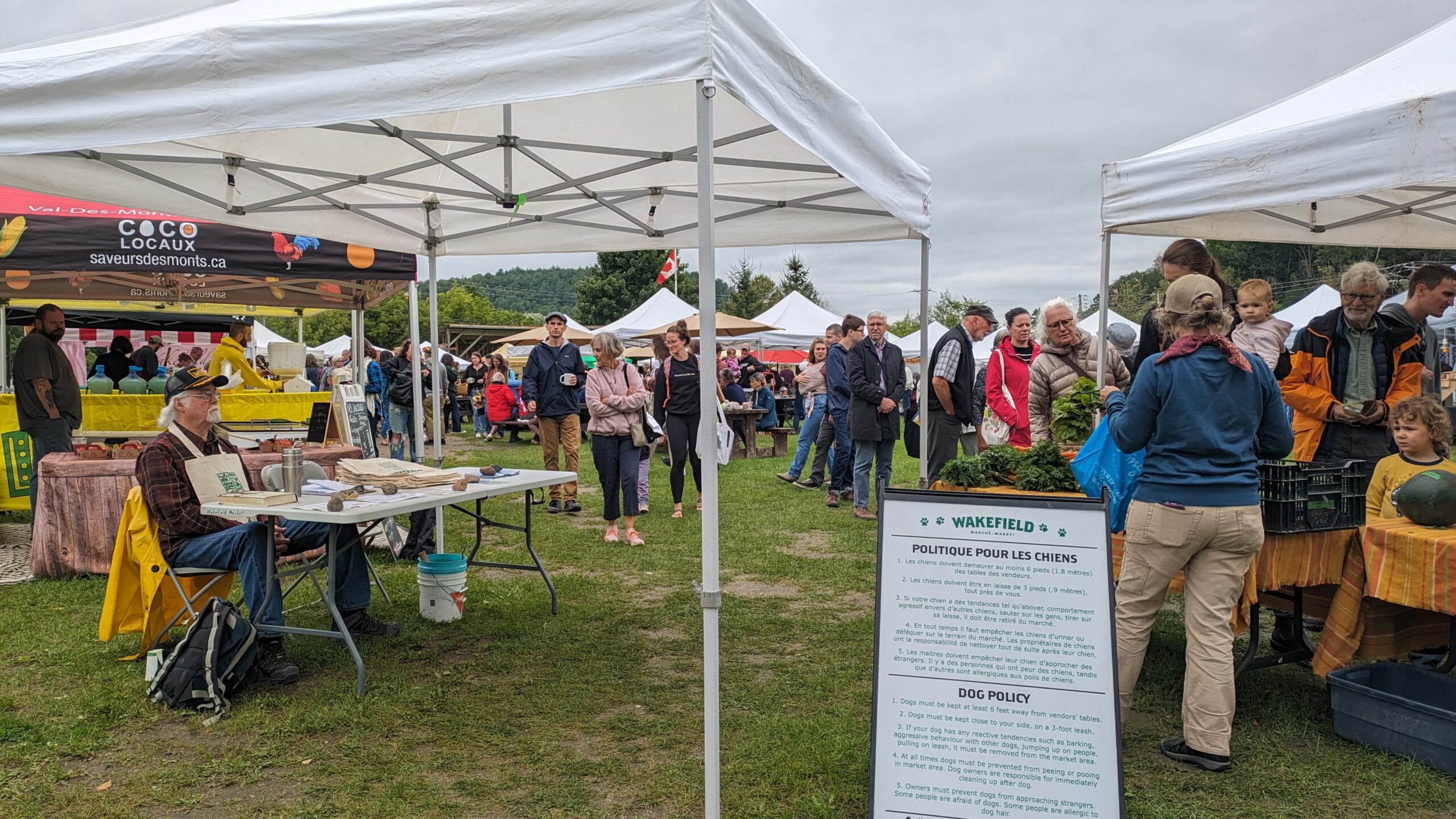 picture of the entrance to the Wakefield farmers market with people and vendor stalls.